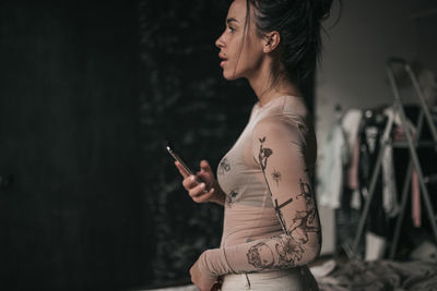 Side view of young woman smoking cigarette