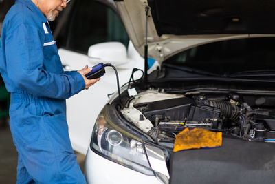 Midsection of mechanic working in mechanic