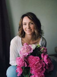 Portrait of smiling woman with pink flower