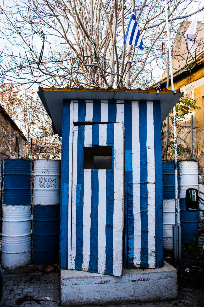 architecture, urban area, building exterior, built structure, tree, building, day, no people, blue, bare tree, house, nature, plant, entrance, home, shed, closed, outdoors, facade, city, door, shack, wall, street, wood, branch