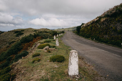 Road leading towards mountains against sky