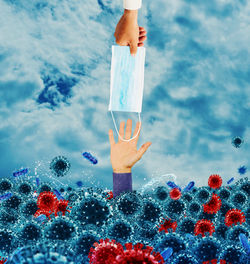 Digital composite image of hand holding umbrella against sea