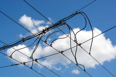 Low angle view of power lines against blue sky