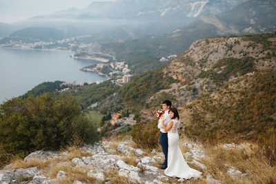 Side view of a young couple standing on mountain