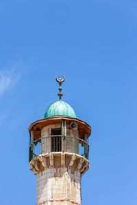 Low angle view of water tower against clear blue sky