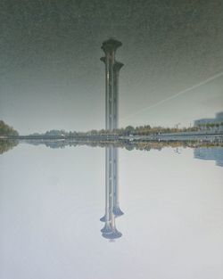 Cross on lake against sky