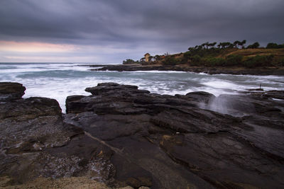 Scenic view of rocks in sea against sky