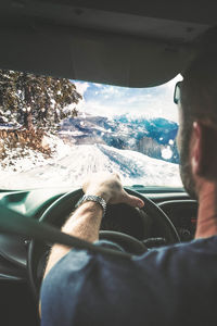 Man seen through car windshield