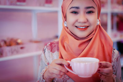 Portrait of a smiling young woman with coffee