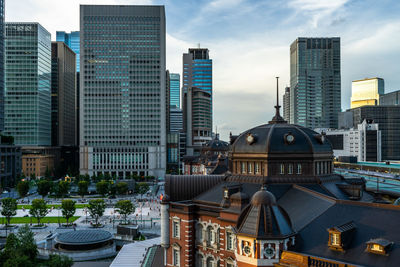 Dome of tokyo station building with skyscraper of chiyoda business district in the background