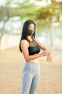 Young woman wearing hat standing against blurred background