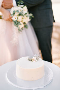 Midsection of bride holding bouquet