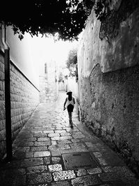 Rear view of people walking on narrow alley