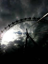 Low angle view of ferris wheel against cloudy sky