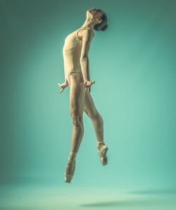 Low angle view of man jumping against sky