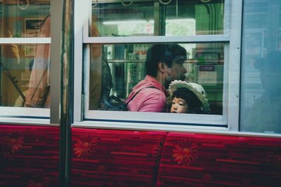 Rear view of couple kissing in glass window