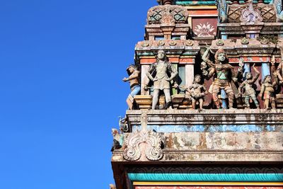 Low angle view of statue against blue sky