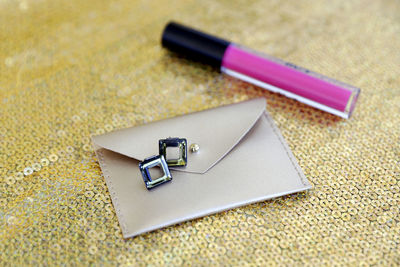 Close-up of pink lipstick and purse on table