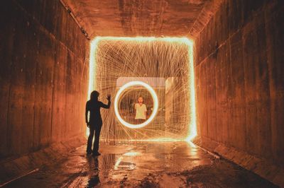 Full length of man standing in illuminated tunnel