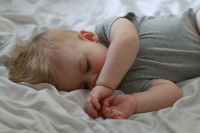 High angle view of baby boy sleeping on bed at home