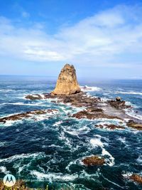 Scenic view of rocks in sea against sky