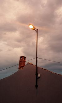 Low angle view of illuminated street light against sky