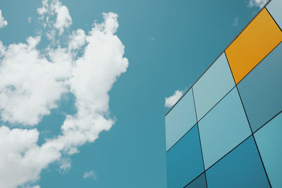 Colored tiles on wall against blue sky