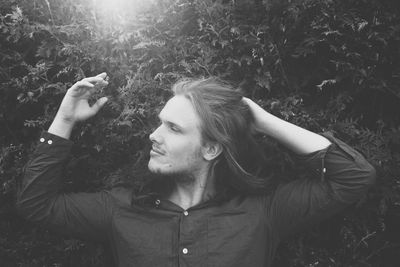 Young man with hand hair standing by plants