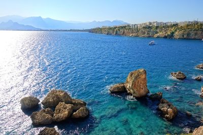 Scenic view of calm sea against mountain range