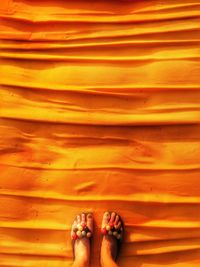 Low section of woman standing on orange carpet