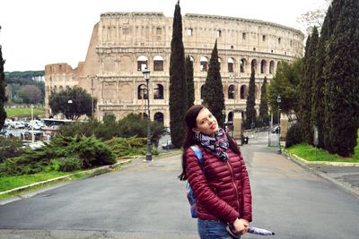 Portrait of woman standing against coliseum