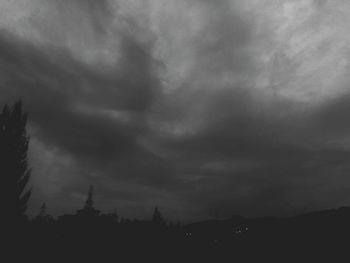 Scenic view of storm clouds over silhouette landscape