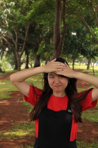 Portrait of girl standing against trees