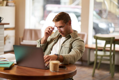 Young woman using laptop at table