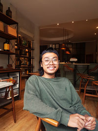Portrait of a smiling young woman sitting in restaurant