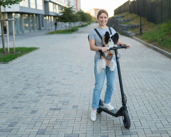 Portrait of young woman walking on footpath