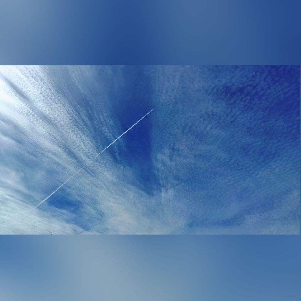 blue, low angle view, sky, airplane, vapor trail, environmental conservation, air vehicle, alternative energy, wind turbine, transportation, nature, day, wind power, copy space, no people, flying, aircraft wing, outdoors, beauty in nature, renewable energy