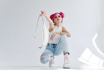 Rear view of woman with arms raised against white background