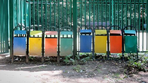 Row of multi colored metallic structure against fence