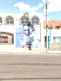 Man standing by building in city against sky