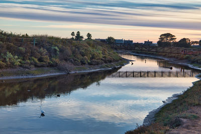 Scenic view of river against sky during sunset