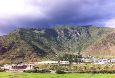 Scenic view of mountain range against cloudy sky