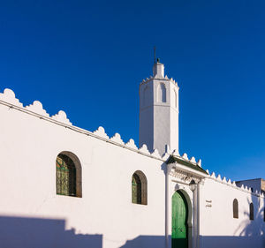 Low angle view of mosque against clear blue sky