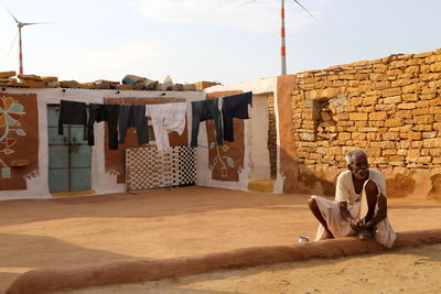 Full length of man sitting on wall