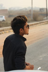 Young man standing on road in city