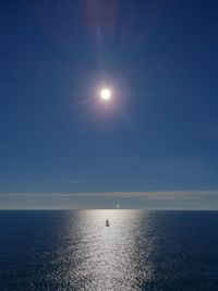 Scenic view of sea against bright sun