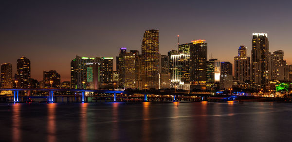 Illuminated buildings in city against sky at night