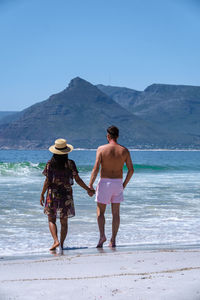 Rear view of woman standing at beach