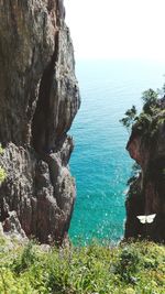 Scenic view of rocks in sea against sky