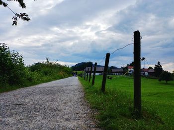Road amidst field against sky